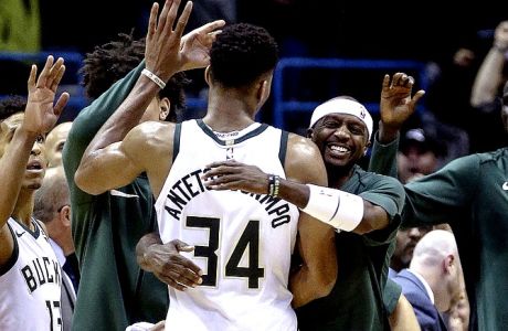 Milwaukee Bucks' Giannis Antetokounmpo is swarmed by teammates at the end of an NBA basketball game against the Portland Trail Blazers, Saturday, Oct. 21, 2017, in Milwaukee. (AP Photo/Tom Lynn)