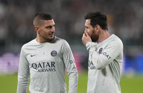 PSG's Lionel Messi, right, speaks with his teammate Marco Verratti during the warm up prior to the Champions League group H soccer match between Juventus and Paris Saint Germain at the Allianz stadium in Turin, Italy, Wednesday, Nov. 2, 2022. (AP Photo/Antonio Calanni)