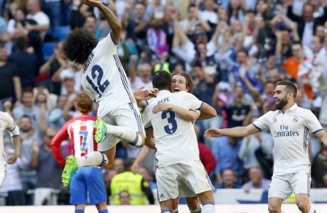 Real Madrid's Pepe, center, celebrates with teammates Luka Modric, center, right, Carbajal, Right, and Marcelo, left, after scoring a goal during a Spain's La Liga soccer match between Real Madrid and Atletico de Madrid at the Santiago Bernabeu stadium in Madrid, Spain, Saturday, April 8, 2017. (AP Photo/Daniel Ochoa de Olza)