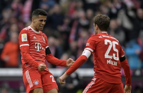 Bayern's Thomas Mueller, right, celebrates with Bayern's Joao Cancelo after scoring his side's opening goal during the Bundesliga soccer match between Bayern Munich and VfL Bochum 1848 at the Allianz Arena in Munich, Germany, Saturday, Feb.11, 2023. (AP Photo/Andreas Schaad)