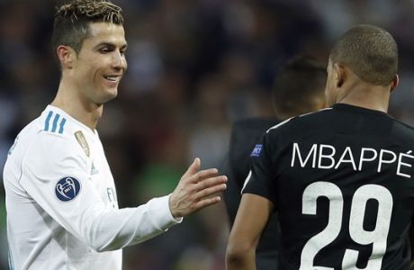 Real Madrid's Cristiano Ronaldo, left, congratulates PSG's Kylian Mbappe at the end of the Champions League Round of 16 first leg soccer match between Real Madrid and Paris Saint Germain at the Santiago Bernabeu stadium in Madrid, Spain, Wednesday, Feb. 14, 2018. Real Madrid defeated PSG 3-1.(AP Photo/Francisco Seco)