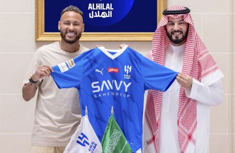 In this photo provided Al Hilal club media center, Neymar holds a Al Hilal shirt after signing with Chairman of the Board of Directors of Al Hilal, Fahad Bin Saad Bin Nafel, in Paris, France, Tuesday, Aug. 15, 2023. (Al Hilal Club Media Center via AP)