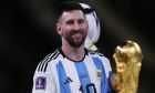 Argentina's Lionel Messi looks at the trophy after winning the World Cup final soccer match between Argentina and France at the Lusail Stadium in Lusail, Qatar, Sunday, Dec.18, 2022. (AP Photo/Manu Fernandez)