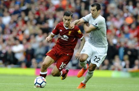 Liverpool's Philippe Coutinho, left, and Manchester United's Henrikh Mkhitaryan, right, battle for the ball during the English Premier League soccer match between Liverpool and Manchester United at Anfield, Liverpool, England, Saturday, Oct. 14, 2017. (AP Photo/Rui Vieira)