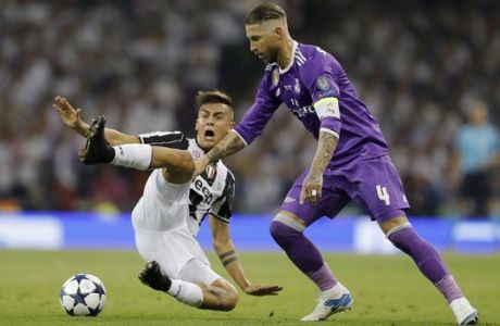 Real Madrid's Sergio Ramos, right, challenges Juventus' Paulo Dybala during the Champions League final soccer match between Juventus and Real Madrid at the Millennium stadium in Cardiff, Wales Saturday June 3, 2017. (AP Photo/Frank Augstein)