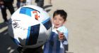 Murtaza Ahmadi, a five-year-old Afghan Lionel Messi fan plays with a soccer ball during a photo opportunity as he wears a shirt signed by Messi, in Kabul, Afghanistan, Friday, Feb. 26, 2016.  Mohammad Arif Ahmadi, the father of the boy who was pictured wearing a homemade Argentina shirt with No. 10 on the back, said Friday they want to thank Messi, a UNICEF goodwill ambassador, in person.(AP Photo/Rahmat Gul)