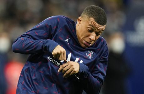 PSG's Kylian Mbappe reacts as he gets hit by the ball during a warm up prior to the Champions League, round of 16, second leg soccer match between Real Madrid and Paris Saint-Germain at the Santiago Bernabeu stadium in Madrid, Spain, Wednesday, March 9, 2022. (AP Photo/Manu Fernandez)