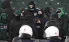 Masked fans are seen on VIP seats in front of riot police moments before violence erupted at a Greek Super League soccer game at the Olympic stadium in Athens on Sunday March 18, 2012. The Greek league game between leader Olympiakos and Panathinaikos has been abandoned with eight minutes to go because of escalating clashes between fans and the police. (AP Photo/Dimitri Messinis)