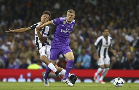 Juventus' Paulo Dybala challenges Real Madrid's Toni Kroos, right, during the Champions League final soccer match between Juventus and Real Madrid at the Millennium stadium in Cardiff, Wales Saturday June 3, 2017. (AP Photo/Dave Thompson)