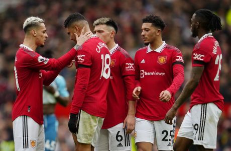 Manchester United's Casemiro, second left, is consoled by teammates after being shown a red card by referee Anthony Taylor during the English Premier League soccer match between Manchester United and Southampton at Old Trafford stadium in Manchester, England, Sunday, March 12, 2023. (AP Photo/Jon Super)