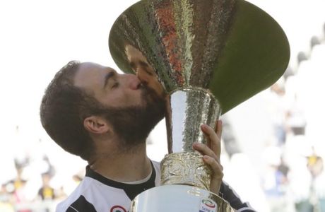 Juventus' Gonzalo Higuain kisses the trophy as Juventus players celebrate winning an unprecedented sixth consecutive Italian title, at the end of the Serie A soccer match between Juventus and Crotone at the Juventus stadium, in Turin, Italy, Sunday, May 21, 2017. (AP Photo/Antonio Calanni)