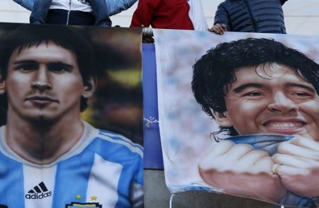 Argentina supporters react as the stand next to pictures depicting Diego Maradona, right, and Lionel Messi before a Copa America Group B soccer match between Argentina and Paraguay at La Portada stadium in La Serena, Chile, Saturday, June 13, 2015. (AP Photo/Andre Penner)