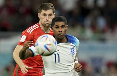 Wales' Ben Davies, left, and England's Marcus Rashford battle for the ball during the World Cup group B soccer match between England and Wales, at the Ahmad Bin Ali Stadium in Al Rayyan , Qatar, Tuesday, Nov. 29, 2022. (AP Photo/Abbie Parr)