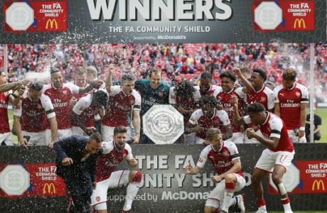 Arsenal players pose with the trophy after winning the English Community Shield soccer match between Arsenal and Chelsea at Wembley Stadium in London, Sunday, Aug. 6, 2017. (AP Photo/Kirsty Wigglesworth)