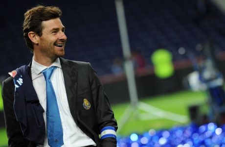 FC Porto's coach Andre Villas-Boas smiles as his team celebrates with the trophy of the champion of the Portuguese Soccer League at the Dragao Stadium in Porto, Portugal, Sunday, May 8, 2011 after their 3-3 draw against Pacos de Ferreira. FC Porto clinched their 25th title. (AP Photo/Paulo Duarte)