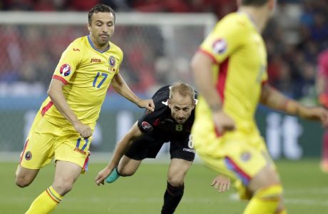 Albania's Migjen Basha, center, looks the ball as Romania's Lucian Sanmartean, left, goes for the ball during the Euro 2016 Group A soccer match between Romania and Albania at the Grand Stade in Decines-­Charpieu, near Lyon, France, Sunday, June 19, 2016. (AP Photo/Pavel Golovkin)