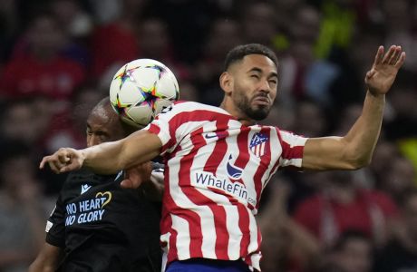 Atletico Madrid's Matheus Cunha, right, jumps for a header with Brugge's Denis Odoi during the group B Champions League soccer match between Atletico Madrid and Club Brugge at the Wanda Metropolitano stadium in Madrid, Spain, Wednesday, Oct. 12, 2022. (AP Photo/Manu Fernandez)