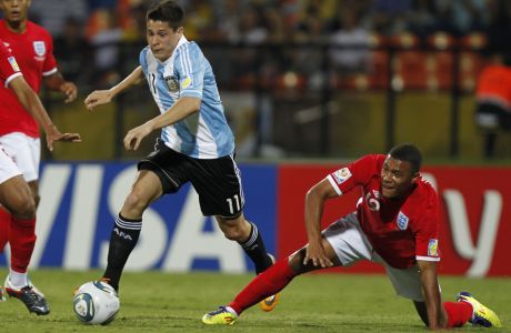 Argentina's Juan Iturbe, center dribbles past England's Reece Brown, left, and England's Recce Wabara during a U-20 World Cup group F soccer match in Medellin, Colombia, Monday, Aug. 1, 2011. (AP Photo/Ricardo Mazalan)
