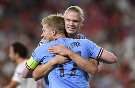 Manchester City's Erling Haaland, facing, embraces Manchester City's Kevin De Bruyne after scoring the opening goal during the group G Champions League soccer match between Sevilla and Manchester City in Seville, Spain, Tuesday, Sept. 6, 2022. (AP Photo/Jose Breton)