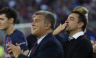 Barcelona club President Joan Laporta, centre and head coach Xavi Hernandez applaud and blow kisses to the fans at the end of a Spanish La Liga soccer match between Barcelona and Mallorca at the Camp Nou stadium in Barcelona, Spain, Sunday, May 28, 2023. (AP Photo/Joan Monfort)