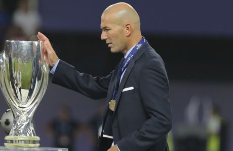 Real Madrid's coach Zinedine Zidane touches the trophy during the Super Cup final soccer match between Real Madrid and Manchester United at Philip II Arena in Skopje, Tuesday, Aug. 8, 2017. Real Madrid defeated Manchester United 2-1. (AP Photo/Boris Grdanoski)