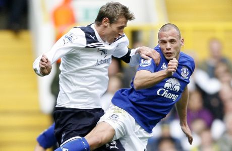 Tottenham Hotspur's Peter Crouch, left, and Everton's Johnny Heitinga vie for the ball during their English Premier League soccer match at White Hart Lane in London, Saturday, Oct. 23, 2010. (AP Photo/Akira Suemori)  ** NO INTERNET/MOBILE USAGE WITHOUT FOOTBALL ASSOCIATION PREMIER LEAGUE(FAPL)LICENCE. CALL +44 (0) 20 7864 9121 or EMAIL info@football-dataco.com FOR DETAILS **