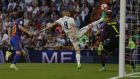 Real Madrid's Karim Benzema stretches to connect to a high ball in front of Barcelona's goalkeeper Marc-Andre Ter Stegen during a Spanish La Liga soccer match between Real Madrid and Barcelona, dubbed 'el clasico', at the Santiago Bernabeu stadium in Madrid, Spain, Sunday, April 23, 2017. (AP Photo/Daniel Ochoa de Olza)