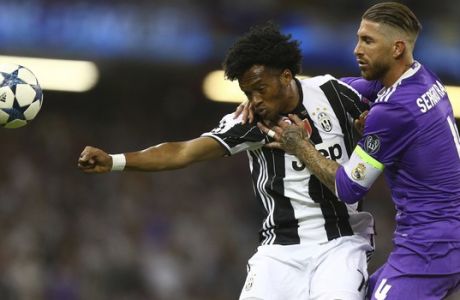 Juventus' Juan Cuadrado, left, and Real Madrid's Sergio Ramos compete for the ball during the Champions League final soccer match between Juventus and Real Madrid at the Millennium stadium in Cardiff, Wales Saturday June 3, 2017. (AP Photo/Dave Thompson)