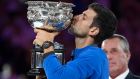 Serbia's Novak Djokovic kisses his trophy after defeating Spain's Rafael Nadal in the men's singles final at the Australian Open tennis championships in Melbourne, Australia, Sunday, Jan. 27, 2019. (AP Photo/Andy Brownbill)
