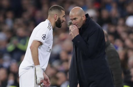 Real Madrid's head coach Zinedine Zidane, right, speaks with Karim Benzema during a Champions League group A soccer match between Real Madrid and Galatasaray at the Santiago Bernabeu stadium in Madrid, Spain, Wednesday, Nov. 6, 2019. (AP Photo/Manu Fernandez)