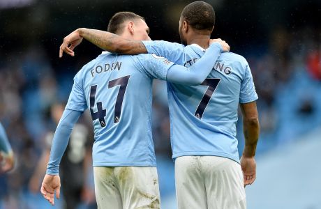 Manchester City's Phil Foden, left, and Manchester City's Raheem Sterling celebrate scoring their side's third goal during the English Premier League soccer match between Manchester City and Everton at the Etihad stadium in Manchester, Sunday, May 23, 2021.(Peter Powel/Pool via AP)