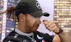 Mercedes driver Lewis Hamilton of Britain rubs his nose during a press conference at the Australian Formula One Grand Prix in Melbourne, Thursday, March 12, 2020. Six-time world champion Lewis Hamilton has questioned the wisdom of staging the season-opening Formula One Grand Prix while other sports are canceling events because of the spreading coronavirus. (AP Photo/Rick Rycroft)