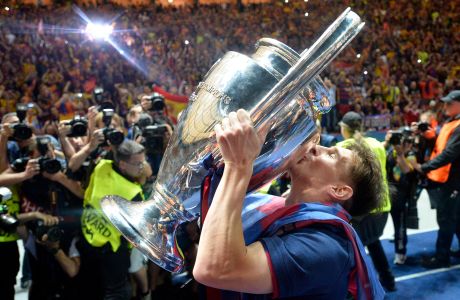 FILE - In this Saturday, June 6, 2015 file photo, Barcelona's Lionel Messi kisses the Champions League trophy after his team defeated Juventus 3-1 in the final at the Olympic stadium in Berlin. Barcelona's victory was its fifth and meant it became the first European team to complete the treble on two occasions. Before the final, Barcelona had secured Spain's two main domestic competitions. (AP Photo/Martin Meissner, File)