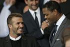 Former England and PSG soccer player David Beckham, left, and former Dutch player Patrick Kluivert take their seats before the Champions League soccer match between PSG and Barcelona, at the Parc des Princes stadium, in Paris, Tuesday, Sept. 30, 2014. (AP Photo/Christophe Ena)