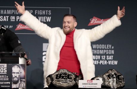 Conor McGregor, center, reacts after taking his opponent Eddie Alvarez's title from a table to put it on his side during a news conference ahead of the UFC 205 mixed martial arts fights, Thursday, Nov. 10, 2016, at Madison Square Garden in New York as UFC president Dana White, left, and fighter Stephen Thompson, right, react. McGregor and Alvarez will fight each other while Thompson will fight Tyron Woodley on Saturday. (AP Photo/Julio Cortez)