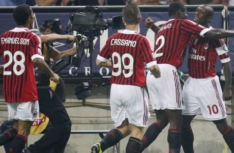 AC Milan midfielder Clarence Seedorf, right, of the Netherlands, celebrates with his tammates after scoring during the Serie A soccer match between AC Milan and Cesena at the San Siro stadium in Milan, Italy, Saturday, Sept. 24, 2011. (AP Photo/Antonio Calanni)