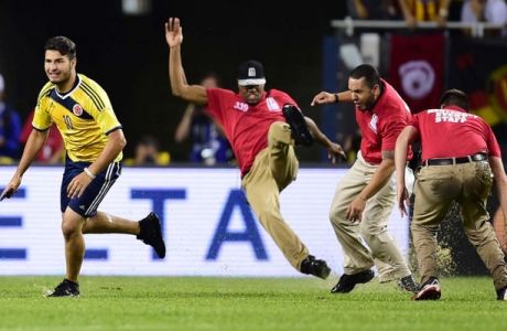 Security personnel run after a field intruder during a Copa America Centenario semifinal football match between Chile and Colombia in Chicago, Illinois, United States, on June 22, 2016. / AFP PHOTO / ALFREDO ESTRELLAALFREDO ESTRELLA/AFP/Getty Images