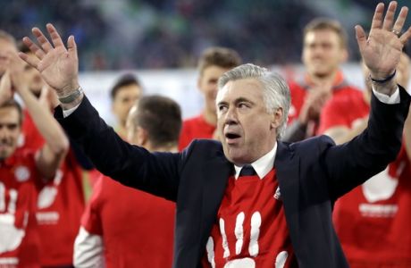Bayern's head coach Carlo Ancelotti and the players celebrate winning the German soccer champion title after the Bundesliga soccer match against VfL Wolfsburg in Wolfsburg, Germany, Saturday, April 29, 2017. (AP Photo/Michael Sohn)