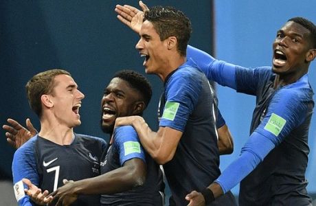 France's Samuel Umtiti, second from left, is congratulated by his teammates France's Antoine Griezmann, Raphael Varane and Paul Pogba, from left, after scoring the opening goal during the semifinal match between France and Belgium at the 2018 soccer World Cup in the St. Petersburg Stadium in St. Petersburg, Russia, Tuesday, July 10, 2018. (AP Photo/Martin Meissner)