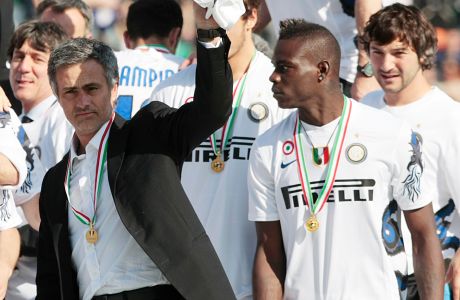 Inter Milan coach Jose Mourinho, left, celebrates his Serie A title flanked by forward Mario Balotelli, at the end of the soccer match between Siena and Inter Milan in Siena, Italy, Sunday, May 16,  2010. Inter Milan beat Siena 1-0 Sunday to seal its fifth consecutive Serie A title and move two-thirds of the way to a possible treble. Inter finished with 82 points, two more than AS Roma, which won 2-0 at Chievo Verona. (AP Photo/Gregorio Borgia)