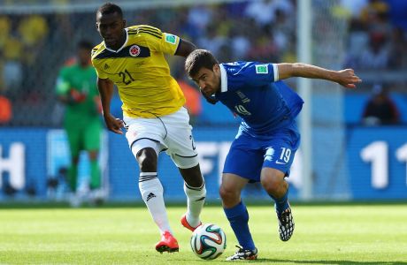 BELO HORIZONTE, BRAZIL - JUNE 14:  Jackson Martinez of Colombia and Sokratis Papastathopoulos of Greece fight for the ball during the 2014 FIFA World Cup Brazil Group C match between Colombia and Greece at Estadio Mineirao on June 14, 2014 in Belo Horizonte, Brazil.  (Photo by Jeff Gross/Getty Images)