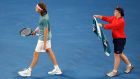 A ball boy offers a towel to Greece's Stefanos Tsitsipas during his fourth round match against Switzerland's Roger Federer at the Australian Open tennis championships in Melbourne, Australia, Sunday, Jan. 20, 2019. (AP Photo/Kin Cheung)