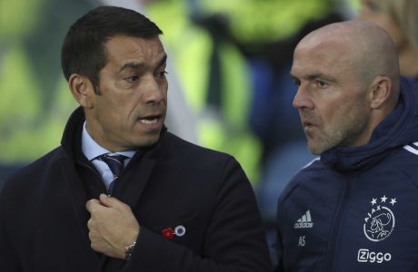 Rangers' Giovanni van Bronckhorst, left speaks to Ajax's head coach Alfred Schreuder just prior to kick off for the Champions League group A soccer match between, Glasgow Rangers and Ajax, at Ibrox stadium in Glasgow, Scotland, Tuesday, Nov. 1, 2022. (AP Photo/Scott Heppell)