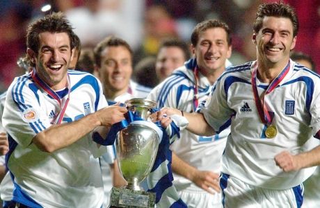 Georgios Karagounis, left, and Theodoros Zagorakis of Greece run with the trophy after their 1-0 victory over Portugal in the Euro 2004 soccer championship final at the Luz stadium in Lisbon, Portugal, Sunday, July 4, 2004. (AP Photo/Dusan Vranic) **  FOR EDITORIAL USE ONLY NO WIRELESS COMMERCIAL OR PROMOTIONAL LICENSING PERMITTED  **