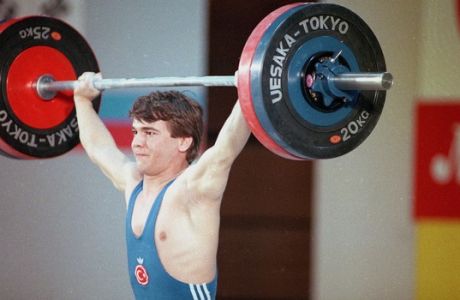 Turkish weightlifter Naim Suleymanoglu strains during the International Sports Fair, May 4, 1989, in Tokyo. (AP Photo/Shizuo Kambayashi)