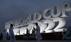People pose for a photograph with a sign reading in English" Fifa World Cup, Qatar 2022" at the corniche in Doha, Qatar, Thursday, Nov. 17, 2022. Final preparations are being made for the soccer World Cup which starts on Nov. 20 when Qatar face Ecuador. (AP Photo/Hassan Ammar)