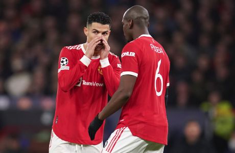 Manchester United's Cristiano Ronaldo, left, talks to teammate Paul Pogba during the Champions League round of 16, second leg soccer match between Manchester United and Atletico Madrid at Old Trafford, Manchester, England, Tuesday, March 15, 2022. (AP Photo/Dave Thompson)