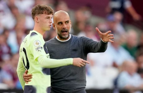 Manchester City's head coach Pep Guardiola instructs Manchester City's Cole Palmer during their English Premier League soccer match between West Ham United and Manchester City at the London Stadium in London, England, Sunday, Aug. 7, 2022. (AP Photo/Frank Augstein)