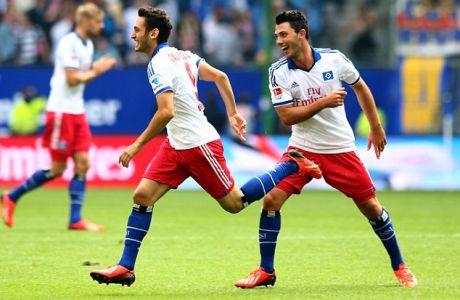 HAMBURG, GERMANY - AUGUST 31: Hakan Calhanoglu (L) of Hamburg celebrates after he scores his team's 3rd goal during the Bundesliga match between Hamburger SV and Eintracht Braunschweig at Imtech Arena  on August 31, 2013 in Hamburg, Germany.  (Photo by Martin Rose/Bongarts/Getty Images)