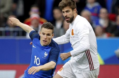 France's Kevin Gameiro, left, and Spain's Gerard Pique, right, challenge for the ball during the international friendly soccer match between France and Spain at the Stade de France in Paris, France, Tuesday, March 28, 2017. (AP Photo/Christophe Ena)